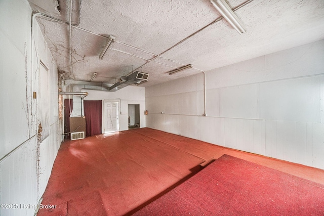 garage featuring a garage door opener and visible vents