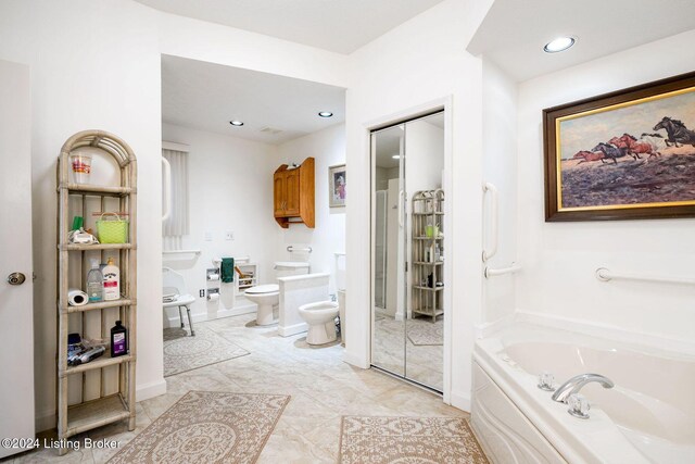 bathroom featuring a tub to relax in, a bidet, and toilet