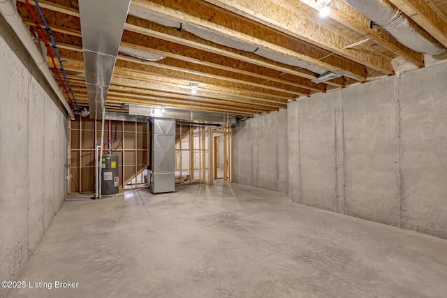 unfinished basement featuring heating unit and electric water heater