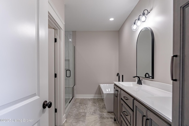 full bath featuring a shower stall, double vanity, recessed lighting, a soaking tub, and a sink