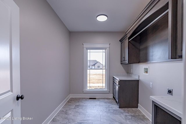 laundry area featuring hookup for a washing machine, cabinet space, baseboards, and hookup for an electric dryer