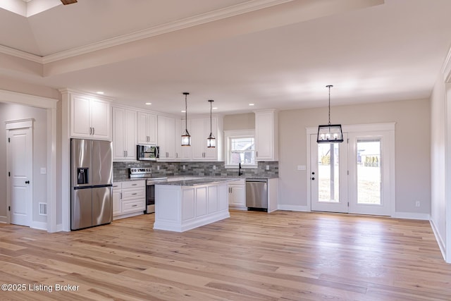 kitchen featuring stainless steel appliances, light wood-style floors, white cabinets, and decorative backsplash