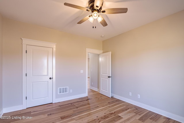 unfurnished bedroom featuring visible vents, a ceiling fan, light wood-type flooring, and baseboards