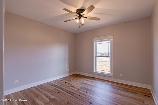 spare room featuring a ceiling fan, wood finished floors, and baseboards