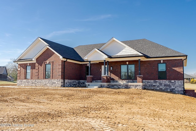 view of front of house with brick siding and a shingled roof