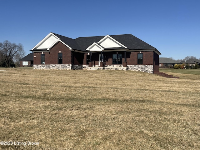 view of front of property with brick siding, a porch, and a front lawn