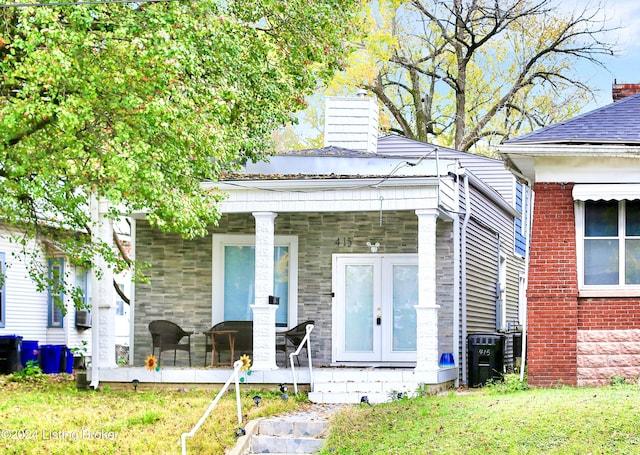 view of front facade featuring central air condition unit, a front lawn, and a porch