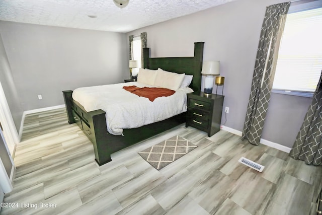 bedroom featuring light wood-type flooring and a textured ceiling