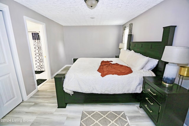 bedroom featuring light hardwood / wood-style floors and a textured ceiling