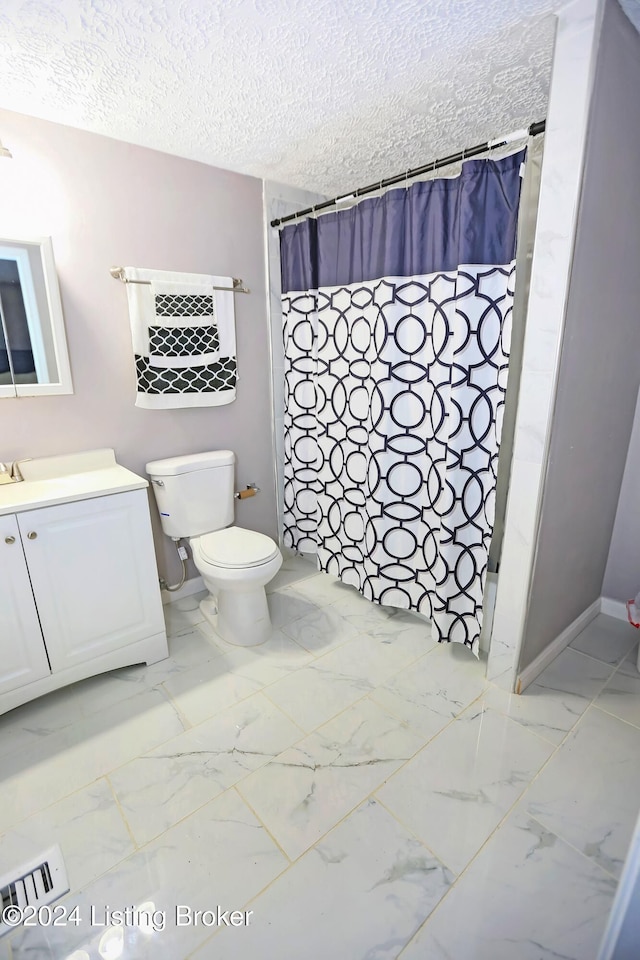 bathroom featuring a shower with shower curtain, vanity, toilet, and a textured ceiling