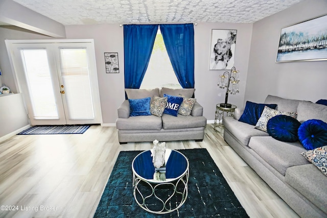 living room with french doors, a textured ceiling, and hardwood / wood-style flooring