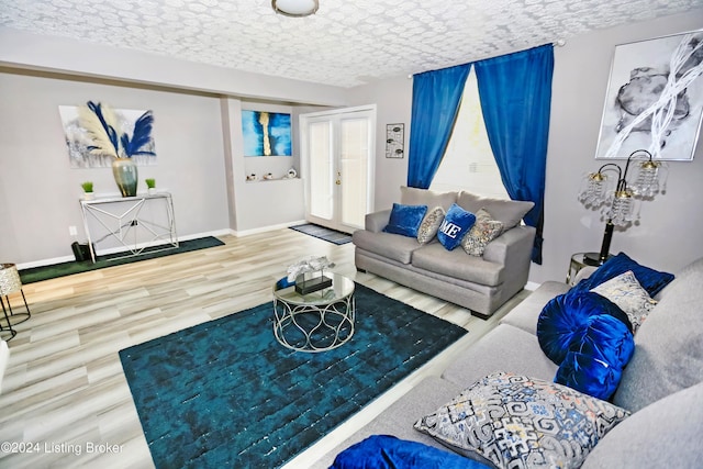 living room with french doors, a textured ceiling, and hardwood / wood-style flooring