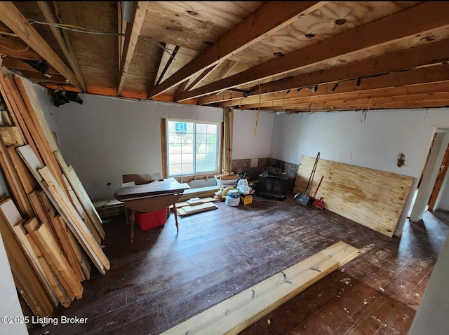 misc room featuring vaulted ceiling, a wood stove, and dark hardwood / wood-style floors