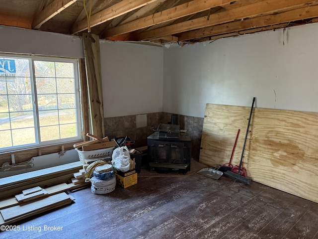 misc room with dark wood-type flooring and a wood stove