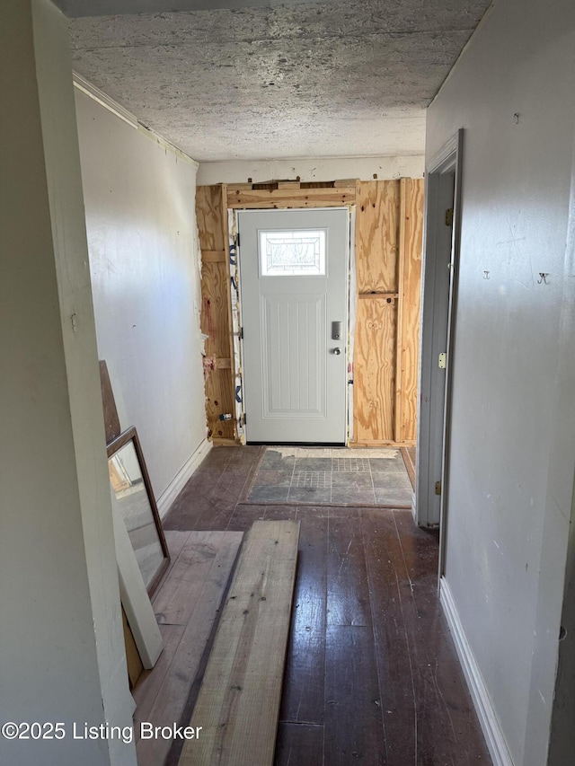 doorway with dark hardwood / wood-style flooring and a textured ceiling