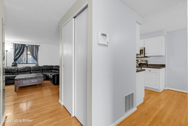 hallway with light hardwood / wood-style floors