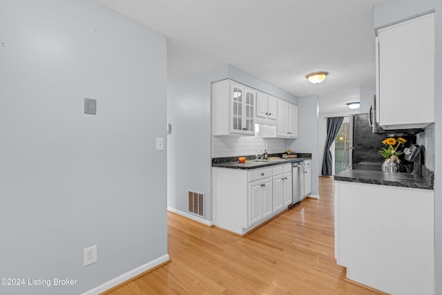 kitchen featuring dishwasher, sink, light hardwood / wood-style flooring, tasteful backsplash, and white cabinetry