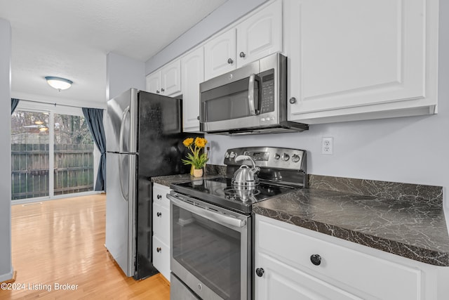 kitchen featuring light hardwood / wood-style flooring, white cabinets, a textured ceiling, and appliances with stainless steel finishes