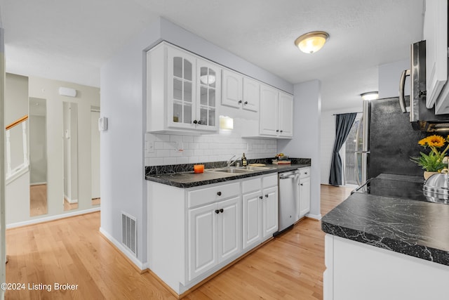 kitchen featuring white cabinets, stainless steel dishwasher, and light wood-type flooring