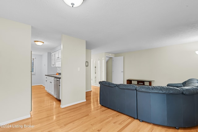 living room featuring a textured ceiling and light wood-type flooring