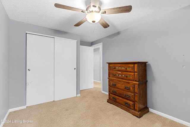 bedroom with light colored carpet, a closet, and ceiling fan