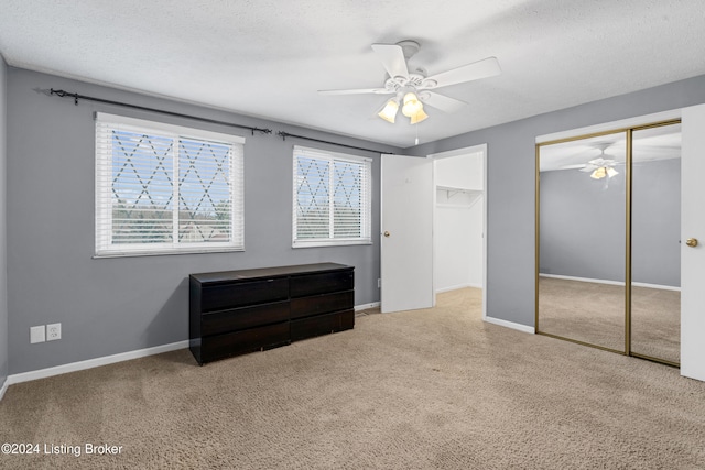 carpeted bedroom with ceiling fan and a textured ceiling