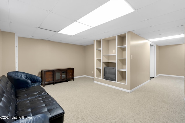 carpeted living room featuring a drop ceiling