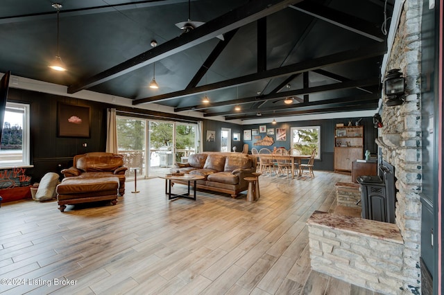 living room with lofted ceiling with beams, light hardwood / wood-style flooring, and a healthy amount of sunlight