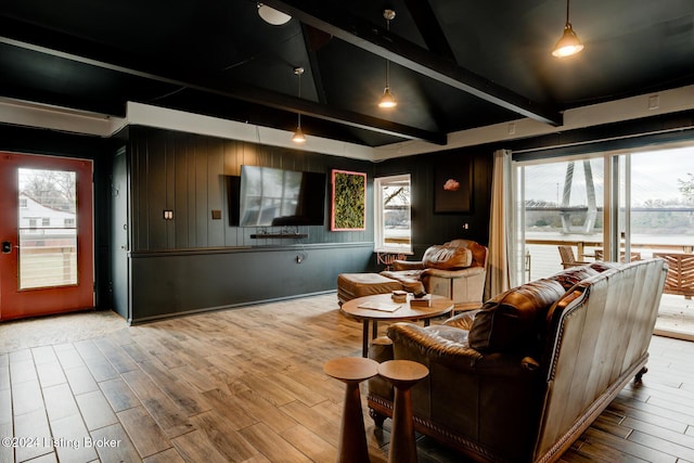 living room with wooden walls, hardwood / wood-style floors, and lofted ceiling with beams