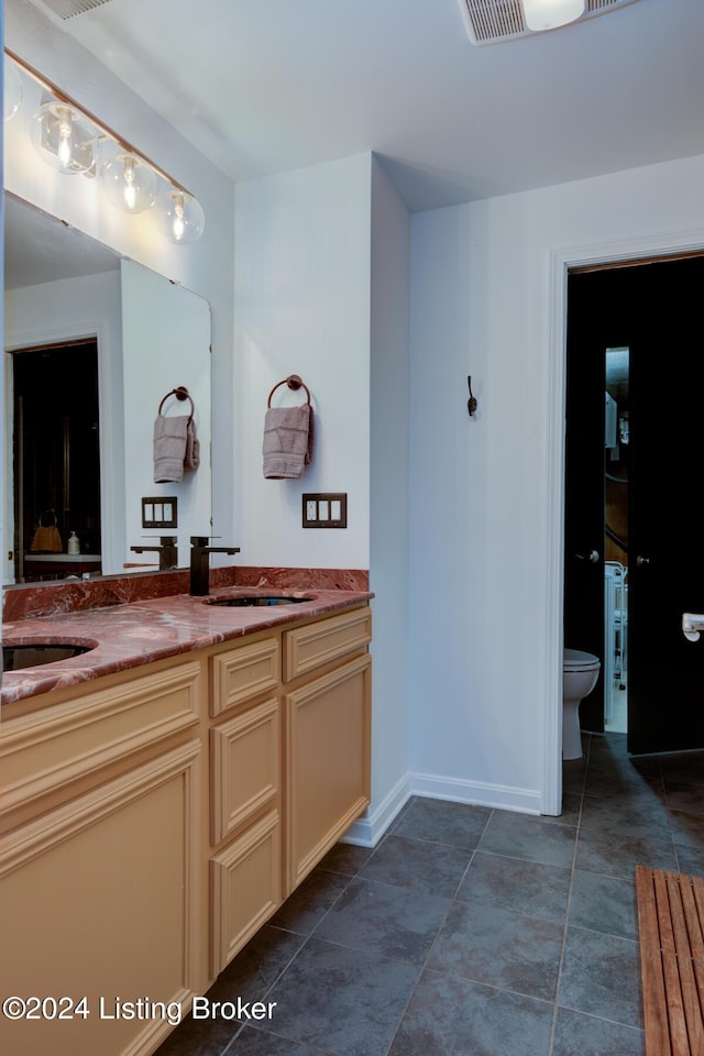 bathroom with tile patterned floors, vanity, and toilet