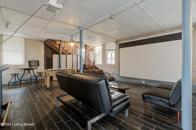 home theater room with ceiling fan and dark wood-type flooring