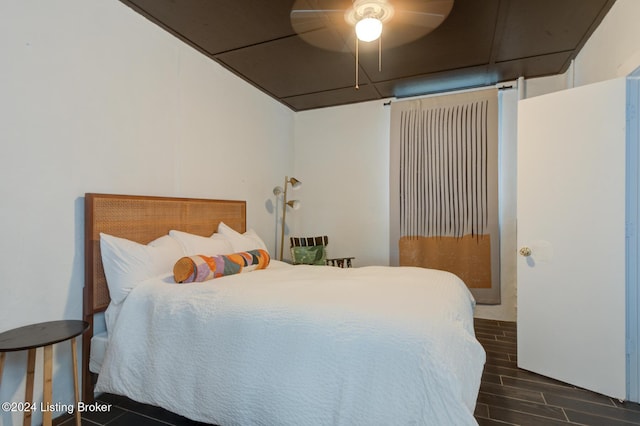 bedroom with dark hardwood / wood-style flooring and ceiling fan