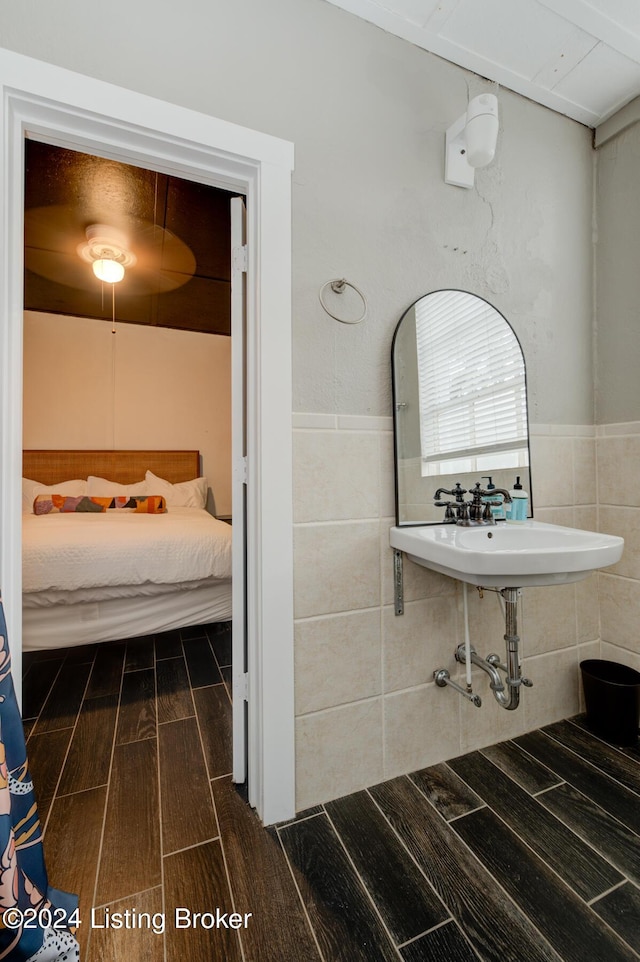 bathroom featuring wood-type flooring and tile walls