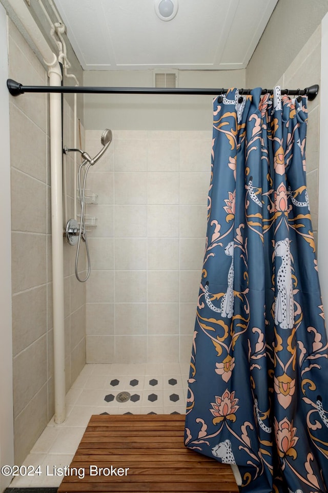 bathroom with a shower with shower curtain and tile patterned floors