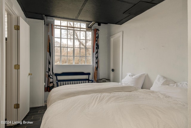 bedroom with dark hardwood / wood-style flooring and radiator heating unit