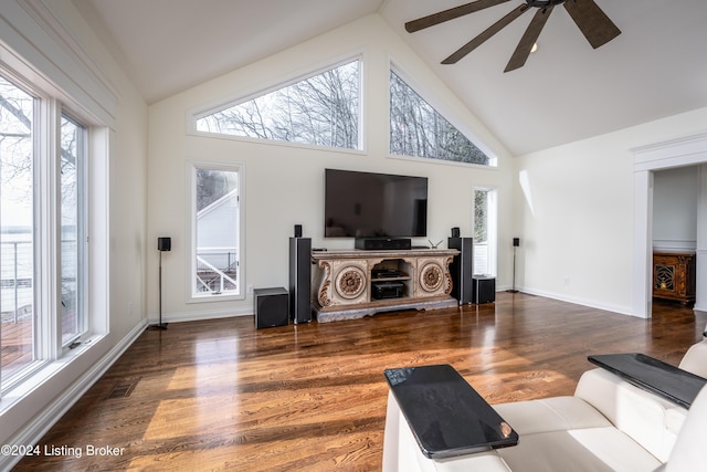 living room with ceiling fan, dark hardwood / wood-style floors, a healthy amount of sunlight, and high vaulted ceiling