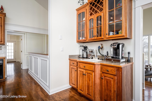 bar with dark hardwood / wood-style flooring and sink