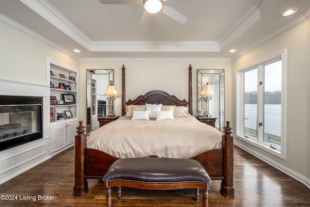 bedroom featuring dark hardwood / wood-style floors, a raised ceiling, ceiling fan, and crown molding