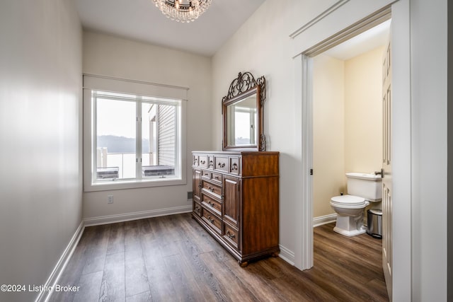 bathroom with hardwood / wood-style floors, an inviting chandelier, and toilet