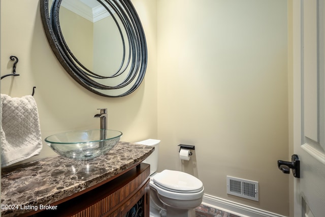 bathroom with crown molding, vanity, wood-type flooring, and toilet