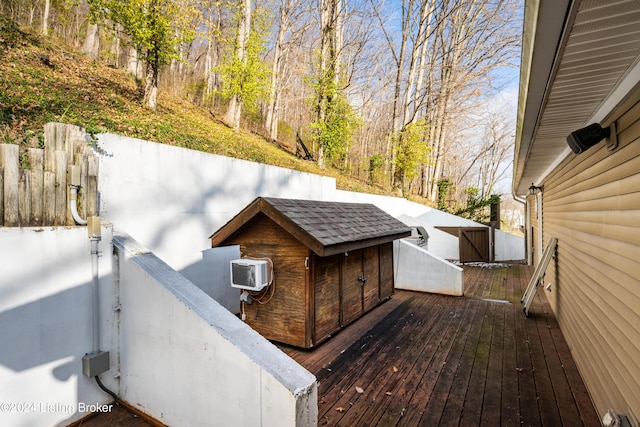 wooden terrace with an AC wall unit and a shed