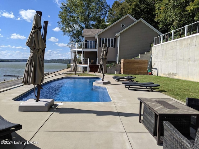 view of swimming pool featuring a patio and a water view