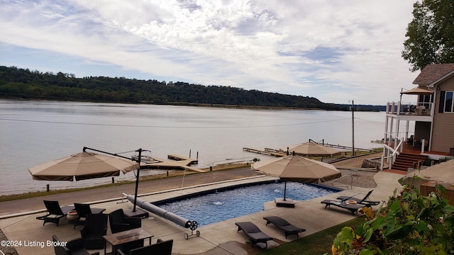 view of swimming pool with a patio and a water view