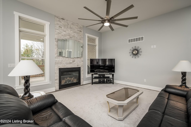 carpeted living room featuring ceiling fan and a fireplace