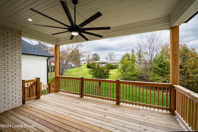 wooden terrace with ceiling fan and a yard