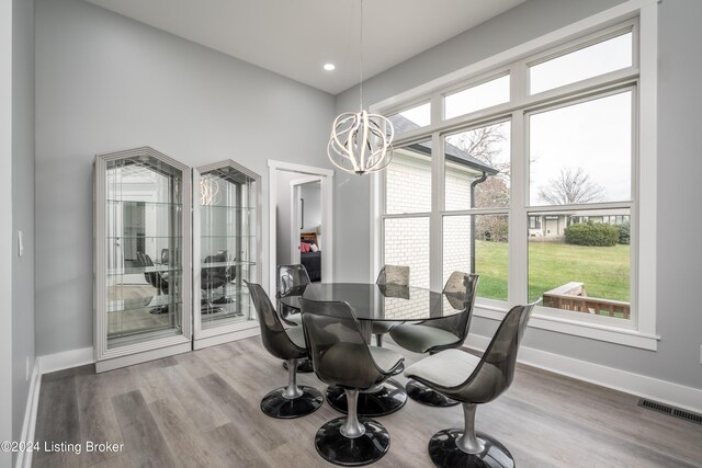 dining room with hardwood / wood-style flooring and a chandelier