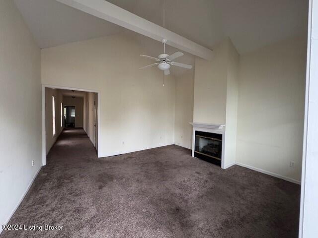 unfurnished living room featuring beam ceiling, ceiling fan, high vaulted ceiling, and dark colored carpet