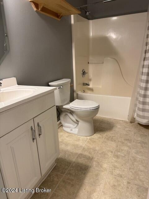 full bathroom featuring tile patterned flooring, shower / bath combo with shower curtain, vanity, and toilet