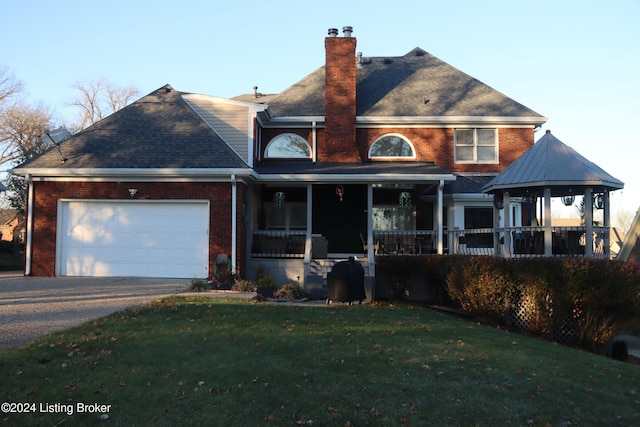 view of front of home with a porch, a garage, and a front lawn