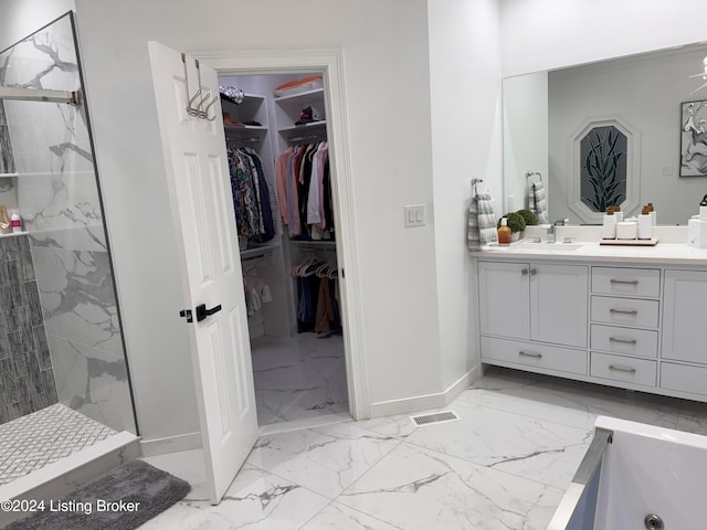 bathroom with a tile shower and vanity